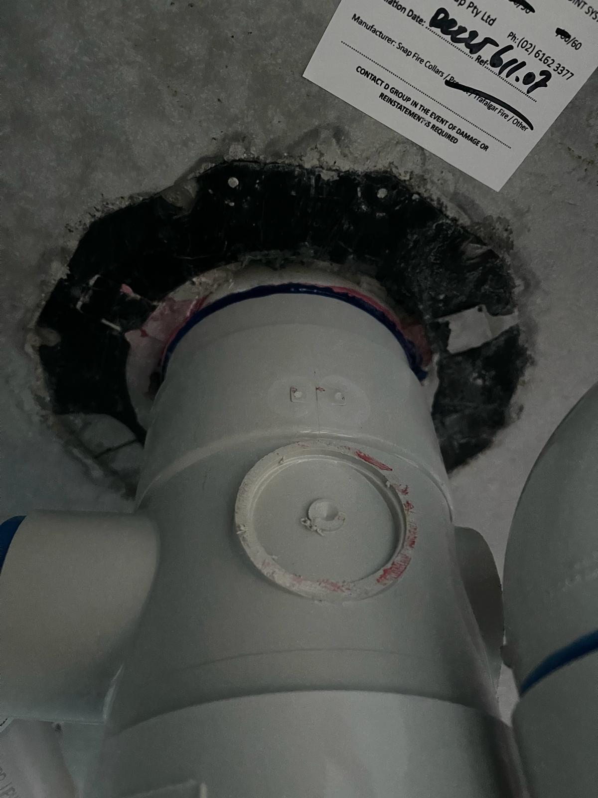 Damaged SNAP cast-in fire collar closure components around a PVC-U penetration below a concrete slab