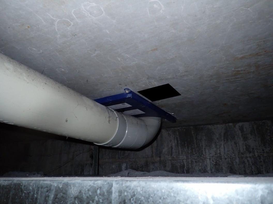 Fendix fire collar installed above a 100 mm PVC-U stack elbow in a confined concrete soffit