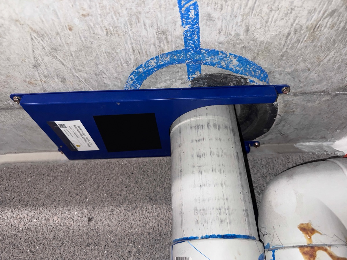 Blue Fendix Collar installed beneath an existing Cougar cast-in collar around a PVC-U floor waste below a concrete slab