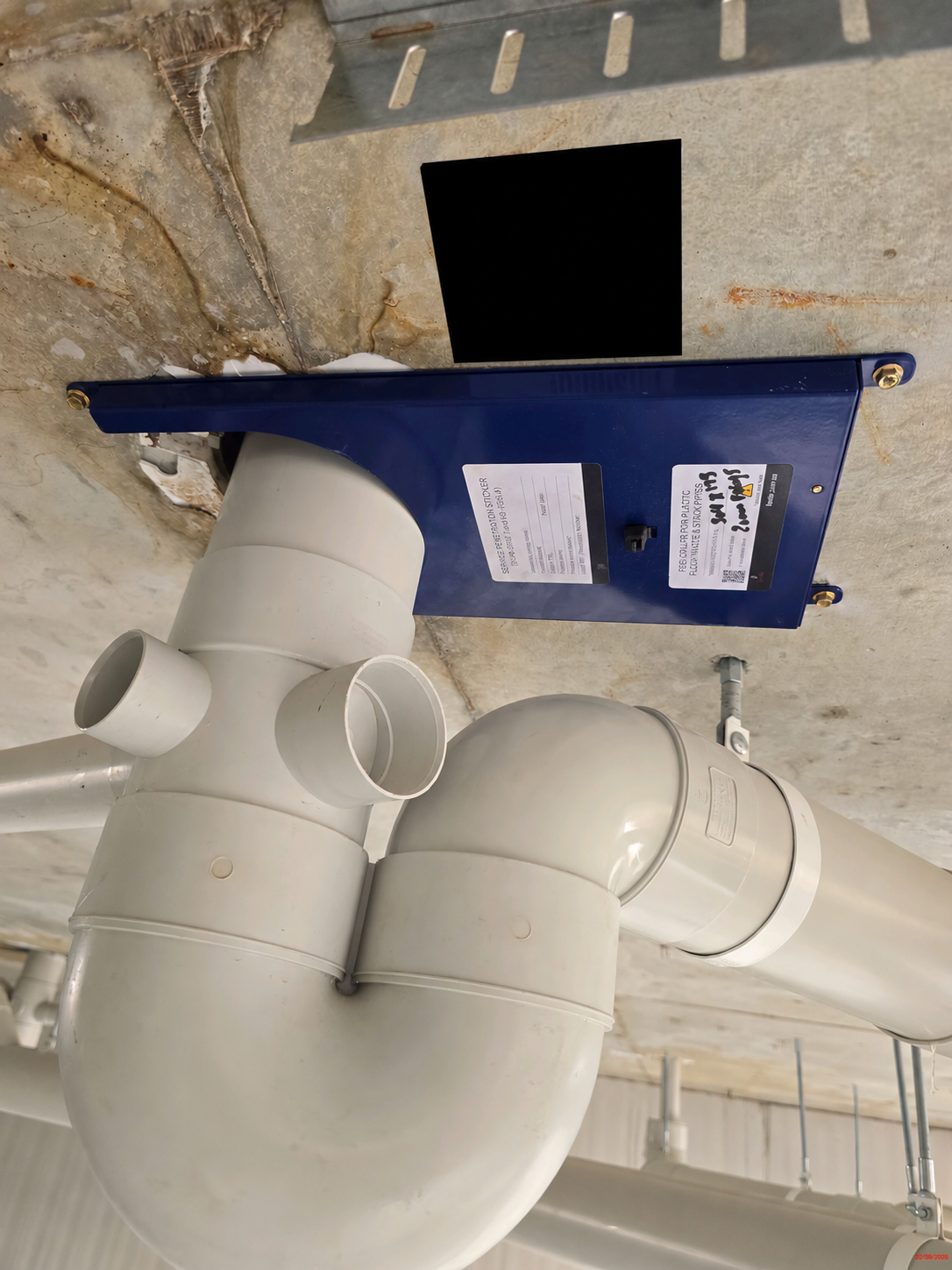 Fendix retrofitted beneath a damaged stack cast-in collar with a floor waste passing through it